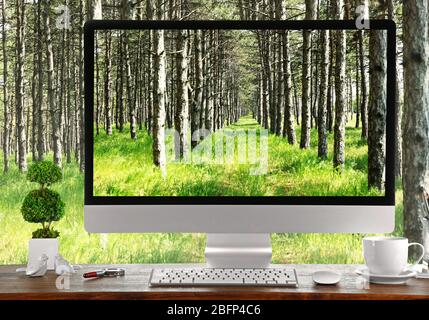 Image conceptuelle d'un espace de travail et d'un ordinateur de bureau avec forêt de pins Banque D'Images