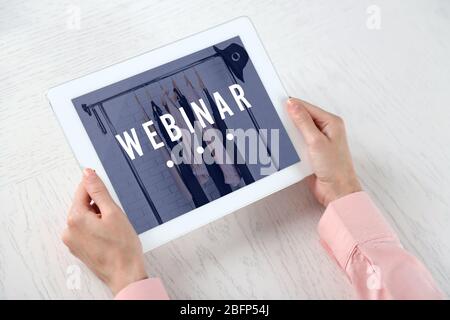 Femme tenant une tablette numérique sur la table. Concept de webinaire Banque D'Images