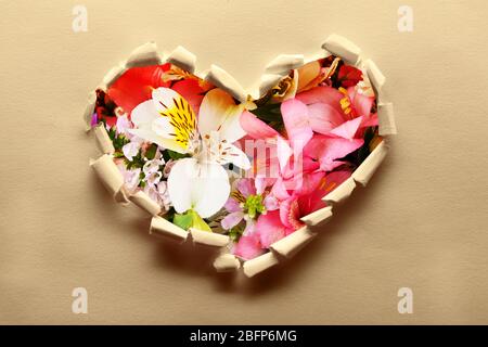 Papier déchiré avec fond de fleurs. Concept d'amour. Banque D'Images