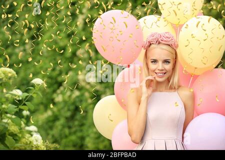 Belle Jeune femme tenant des ballons d'air dans le jardin Banque D'Images