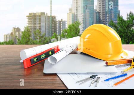 Plans de construction avec outils et casque sur le fond de construction de bâtiment Banque D'Images