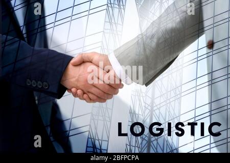 Concept logistique. Double exposition. Les hommes d'affaires se secouent les mains et le fond du gratte-ciel Banque D'Images