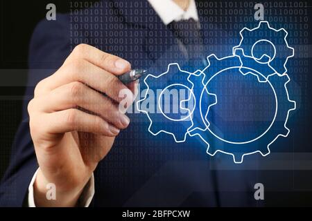 Homme d'affaires qui tire une partie du mécanisme sur l'écran virtuel. Concept de stratégie commerciale. Banque D'Images