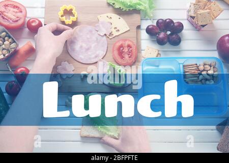 Concept de déjeuner scolaire. Femme qui fait un délicieux sandwich sur la table Banque D'Images