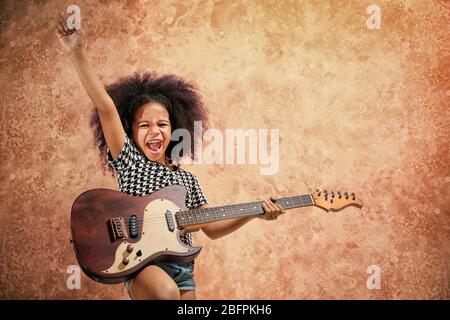 Petite fille afro-américaine jouant de la guitare sur fond grunge Banque D'Images