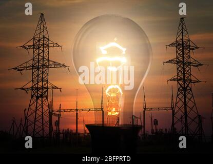 Tours de transmission électrique, sous-station et ampoule sur fond de ciel au coucher du soleil Banque D'Images