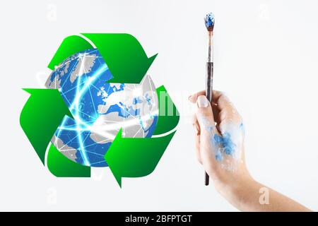 Globe, signe de recyclage et main féminine avec brosse sur fond blanc. Écologie et conservation de l'environnement Banque D'Images