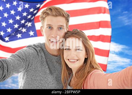 Un jeune couple a tailler le selfie et le drapeau des États-Unis sur fond Banque D'Images