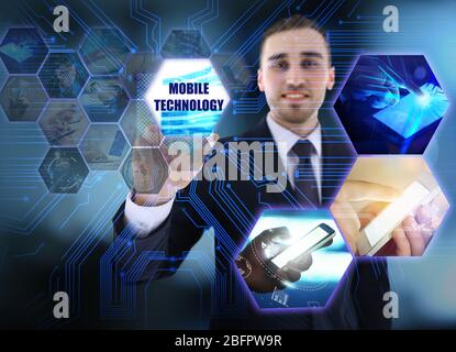 Jeune homme appuyant SUR le bouton TECHNOLOGIQUE MODERNE connecté aux gadgets sur l'écran virtuel Banque D'Images