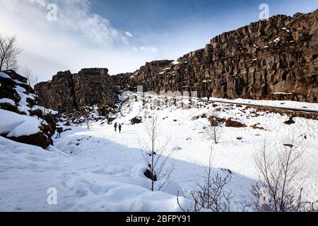 Les falaises de la ligne de faille Almannagja dans la crête de l'Atlantique milieu dans le parc national de Thingvellir (Þingvellir) dans le sud-ouest de l'Islande en neige en hiver Banque D'Images