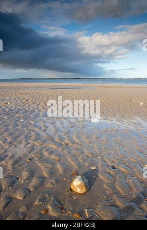 Une plage de sable vide avec une piscine d'eau, la texture du sable est montrée au premier plan, hayling Island, Hampshire, Royaume-Uni Banque D'Images