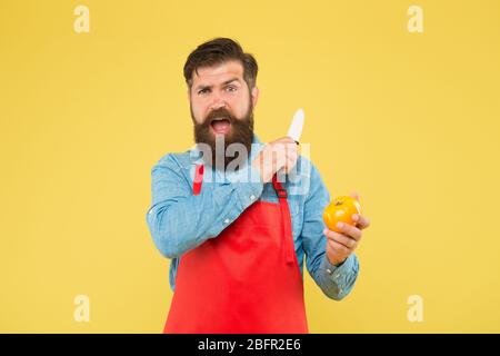 Homme mûr tenir couteau et légumes. Le chef prépare le repas. Coupe sûre. Couper des légumes. Liste ultime des techniques de coupe que chaque chef devrait savoir. Homme barbu préparer la tomate. Recette de salade fraîche. Banque D'Images