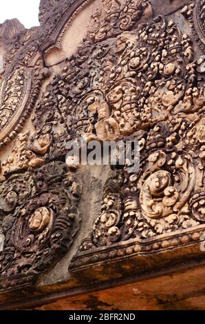 Gros plan sur la façade ornée du temple hindou ancien de Banteay Srei, avec des fleurs et un dieu hindou dans le site historique d'Anges Wat, Siem Reap, Cambodge Banque D'Images