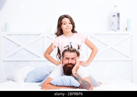 Soirée pyjama. Coiffeur ou styliste. Coiffure drôle. Compressé dans les limites de la maison. Bonne enfance. Détente dans la chambre. Fille et père. Quarantaine avec les enfants. Bonne famille. Loisirs en famille. Banque D'Images