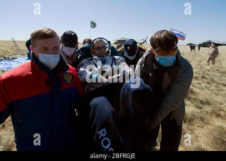 ZHEZKAZGAN, KAZAKHSTAN - 17 avril 2020 - le personnel de soutien russe travaille autour de l'engin spatial Soyuz MS-15 peu après avoir atterri dans une zone éloignée près Banque D'Images