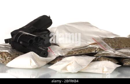 Cocaïne et marijuana en paquet avec un pistolet isolé sur blanc Banque D'Images