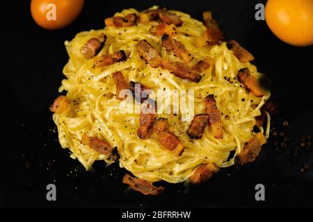 Spaghetti alla Carbonara, guanciale, rosso d'uovo, pecorino romano e pepe. Recettes italiennes de carbonara. Banque D'Images