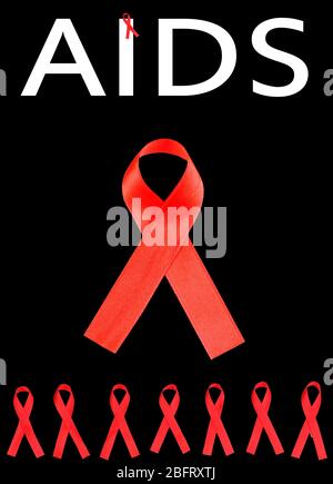 Rubans rouges de sensibilisation au SIDA isolés sur le noir Banque D'Images