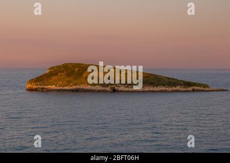 Île Rocky au large de la côte de la péninsule de Gargano au coucher du soleil. Italie Banque D'Images