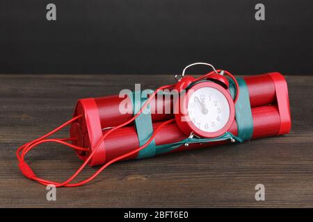 Bombe à retardement à base de dynamite sur table en bois sur fond gris Banque D'Images