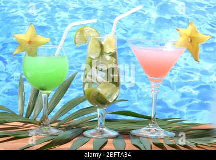 Verres de cocktails sur table en bois sur fond bleu de mer Banque D'Images