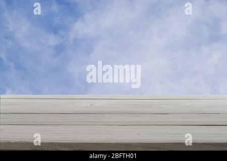 Bois gris rustique contre un ciel bleu nuageux. Banque D'Images