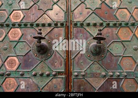 Poignées de portes ornées sur une porte en métal à une mosquée de la Médina de Fès Maroc Banque D'Images