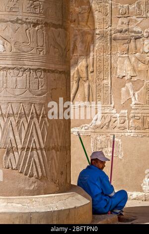 Un travailleur prend une pause au Temple d'Horus à Edfu, en Egypte. Banque D'Images