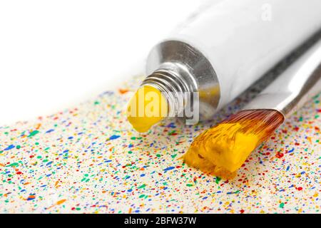 brosses avec peinture colorée et tube avec aquarelle sur des éclaboussures colorées fond gros plan Banque D'Images