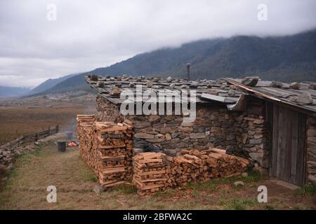 Un bain traditionnel en pierre chaude avec un feu de camp et une vue sur la vallée de Phobjika, au Bhoutan. Banque D'Images