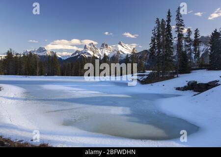 Lac gelé et paysage de montagnes Rocheuses de Snowy à distance au début du Springtime. Bow Valley, Canmore Alberta Canada Banque D'Images