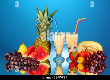 Le lait se shakes avec des fruits sur fond bleu gros plan Banque D'Images