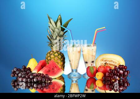 Le lait se shakes avec des fruits sur fond bleu gros plan Banque D'Images