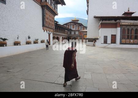 Un jeune moine se promène à l'intérieur de Rinpung Dzong, le principal monastère et forteresse de Paro, au Bhoutan, qui date de 1645 et contient 14 sanctuaires et chapelles. Banque D'Images