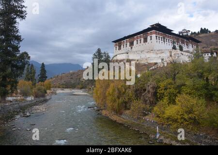 Rinpung Dzong, le monastère principal et la forteresse de Paro, au Bhoutan, date de 1645 et est atteint par le pont Nemi Zam au-dessus du fleuve Paro. Banque D'Images