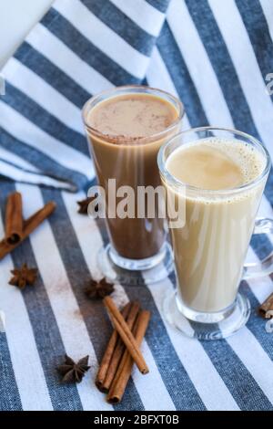 Café glacé avec lait dans de grands verres, tasses de café savoureux à la frappe, Latte machiato, deux tasses de cappuccino avec des bâtons de cannelle et des étoiles anis Banque D'Images