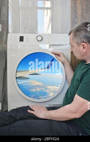 Isolation passager mâle regardant par une fenêtre de lavage de Mashine comme un plan Banque D'Images