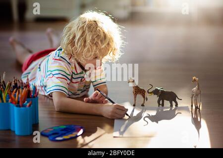 Enfants animaux de dessin d'ombre. Les enfants jouent à la maison. Artisanat amusant pour enfants de maternelle. Petit garçon peinture girafe et éléphant dans la chambre ensoleillée. Jeu Banque D'Images