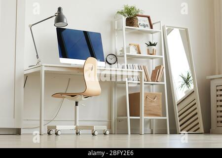 Vue à faible angle sur le bureau à domicile blanc avec chaise en bois et ordinateur moderne sur le bureau, espace de copie Banque D'Images