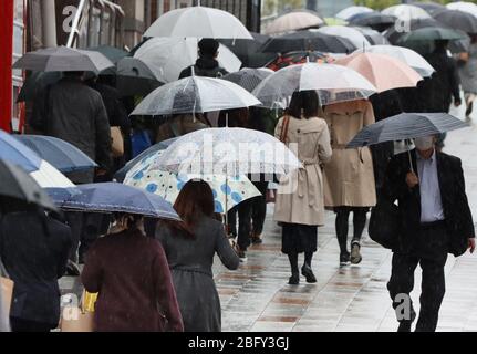 Tokyo, Japon. 20 avril 2020. Sous la pluie, les travailleurs se rendent à leurs bureaux à Tokyo le lundi 20 avril 2020. Le gouvernement japonais a élargi l'état d'urgence à l'échelle du Japon pour prévenir l'éclosion du nouveau coronavirus. Crédit: Yoshio Tsunoda/AFLO/Alay Live News Banque D'Images