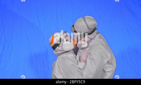Médecin homme et femme en costume de protection, protection au gaz masque de peinture pour spray médical. J'adore le baiser et le câlin de couple, un professionnel de la santé dans le respirateur Covid-19. Banque D'Images