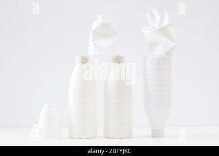 Composition minimale des bouteilles et des articles en plastique blanc sur fond blanc, concept de tri et de recyclage des déchets Banque D'Images