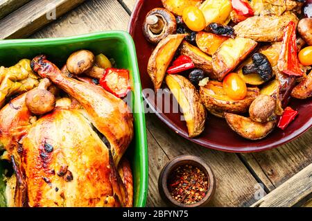 Poulet cuit avec pommes sur une table en bois ancienne.poulet frit avec pommes.poulet rôtisserie aromatique savoureux Banque D'Images