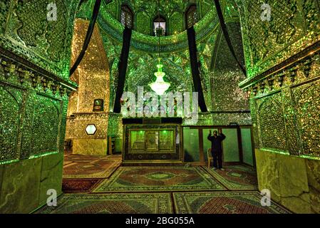 Homme priant sur la tombe d'emir Ali à Imamzadeh-ye Ali ebn-e Hamze, Shiraz, Iran Banque D'Images