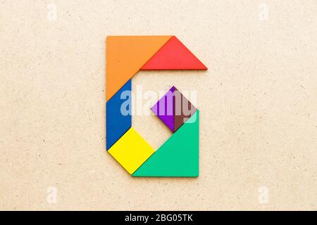 Puzzle en forme de lettre G de tangram sur fond de bois Banque D'Images