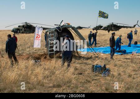 ZHEZKAZGAN, KAZAKHSTAN - 17 avril 2020 - le personnel de soutien russe travaille autour de l'engin spatial Soyuz MS-15 peu après avoir atterri dans une zone éloignée près Banque D'Images