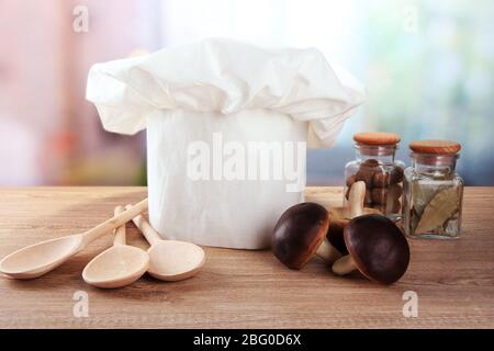 Chapeau de chef avec cuillères sur table dans la cuisine Banque D'Images