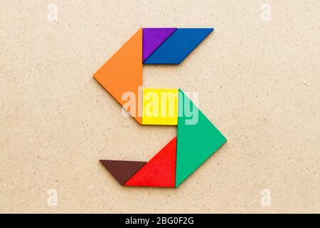 Puzzle en forme de lettre S de tangram sur fond de bois Banque D'Images