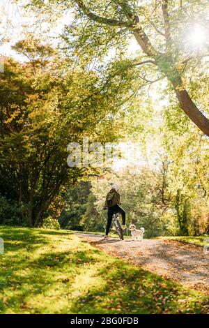 19/4/2020 femme asiatique avec un vélo alimentant un chien en automne dans le jardin botanique, Oamaru, Nouvelle-Zélande. Concept de l'exercice alors que l'isolement social fr Banque D'Images