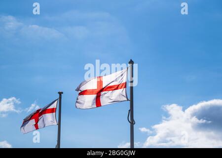 Drapeaux de la Croix de St George flambants dans le vent vu contre un ciel bleu. Banque D'Images